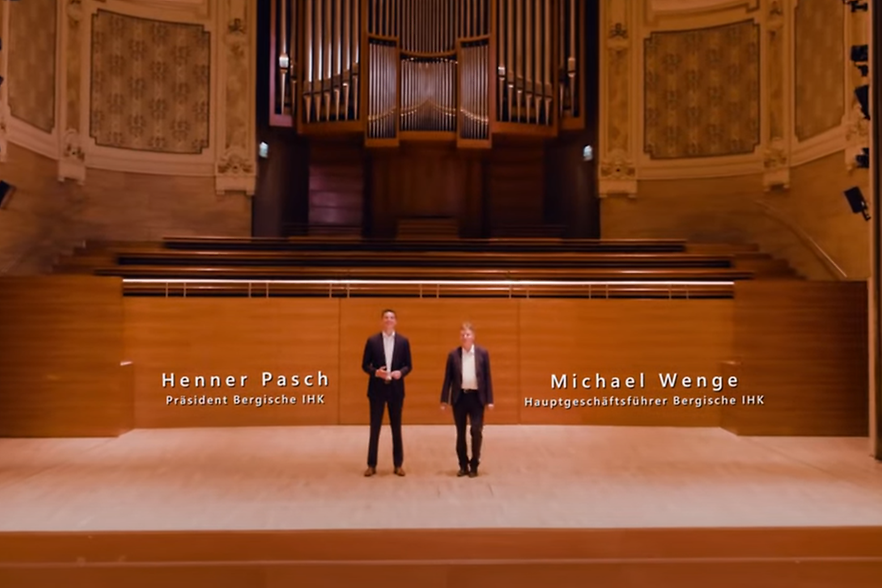 IHK-Präsident Thomas Meyer und IHK-Hauptgeschäftsführer Michael Wenge auf der Bühne der historischen Stadthalle Wuppertal.
