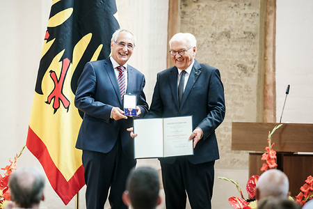 Der Bundespräsident übergibt einem Unternehmer eine hochrangige Auszeichnung.