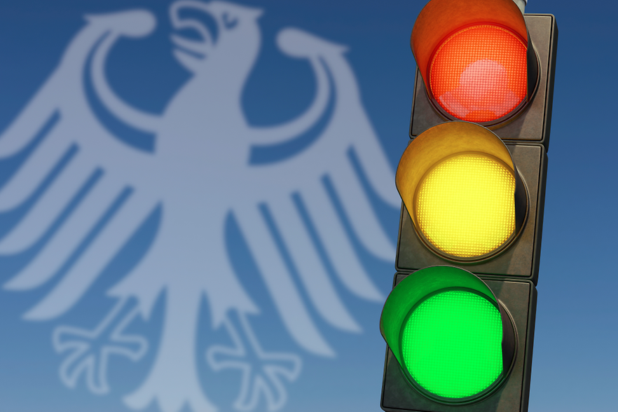 im Vordergrund eine Ampel, im Hintergrund das Adlersymbol